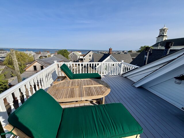 Roof deck with two chair, table, town, and bay views