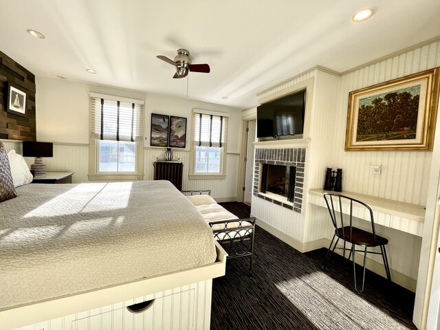 King bed, two windows, fireplace, and writing area in our Race Point Room 