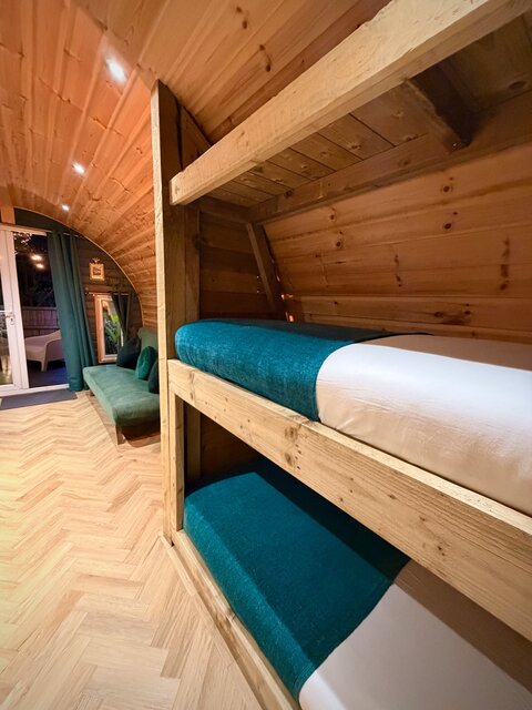 “Close-up of neatly made bunk beds in a child-friendly bedroom, showcasing a cozy, stylish, and inviting space perfect for kids at The Secret Garden Glamping.”