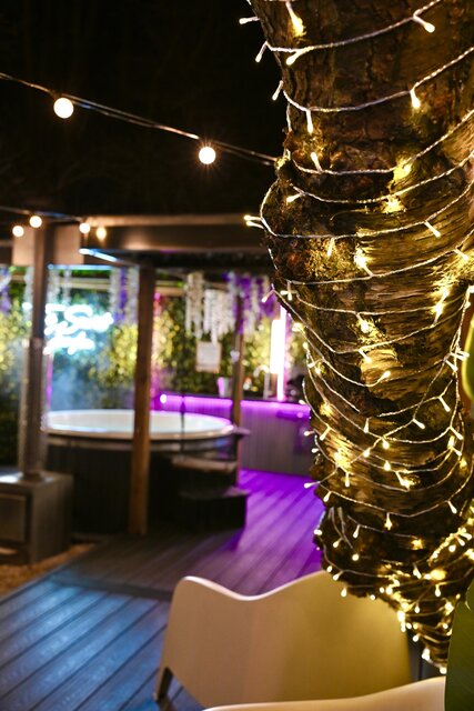 “A beautifully lit tree wrapped in glowing fairy lights, with The Keep’s pod illuminated behind it, showcasing the warm, inviting luxury ready for guests.”