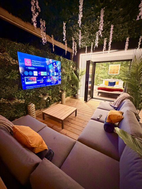 “The Blossom pod outdoor seating area at The Secret Garden Glamping featuring two perfectly arranged couches for ultimate comfort, centered around a luxurious coffee table.