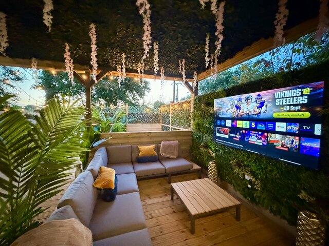 “The Blossom pod’s outdoor seating area showcasing two comfortable couches positioned around a stylish coffee table that matches the golden-brown decking.