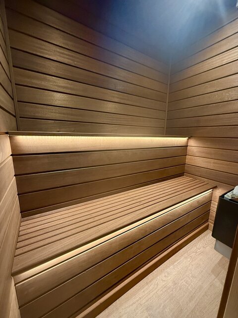 The Vista outdoor sauna at The Secret Garden Glamping featuring warm under-seat lighting, creating a modern, cozy, and luxurious atmosphere.
