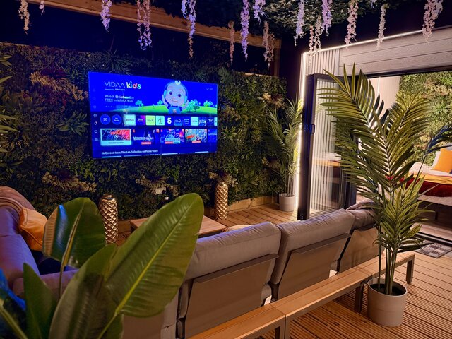 “Outdoor seating at the Blossom pod with two thoughtfully positioned couches for maximum comfort, surrounding a stylish coffee table that matches the golden-brown decking. 