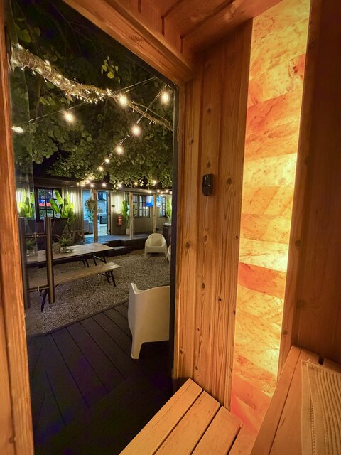 View from inside the wooden sauna looking out onto the outdoor area, featuring natural surroundings, warm timber details and a glimpse of the relaxing exterior space at The Secret Garden Glamping.