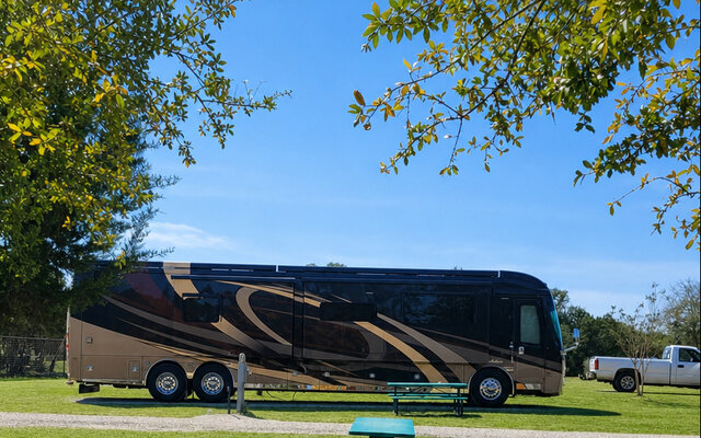 RV Space 8 at Al’s Hideaway Cabins & RV Rentals in Pipe Creek TX, large gravel pad with shade trees and picnic table for Hill Country camping.
