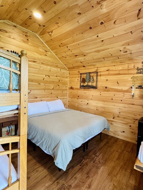 Cabin interior view with queen bed and bunk beds