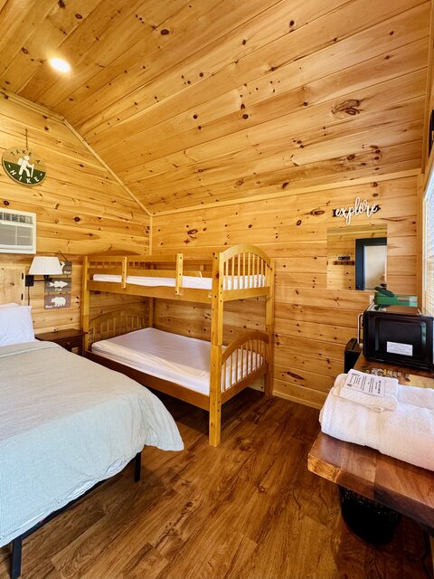 Interior view of cabin with queen bed and bunk beds