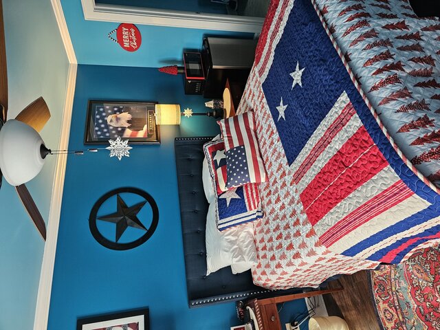 “Red, white, and blue-themed queen room with fireplace and soaking tub, honoring military guests at a boutique North Carolina inn.”