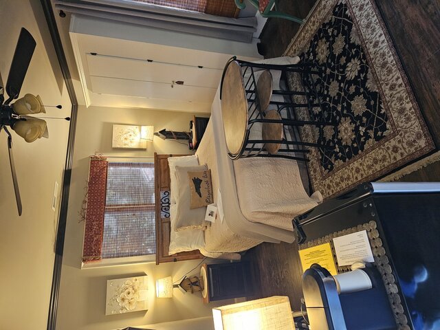 Airy second-floor queen room in soothing green tones with courtyard views and large soaking tub.”