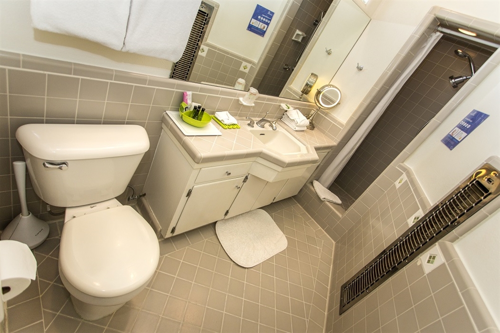 A standard hotel bathroom with a toilet, sink, and shower.